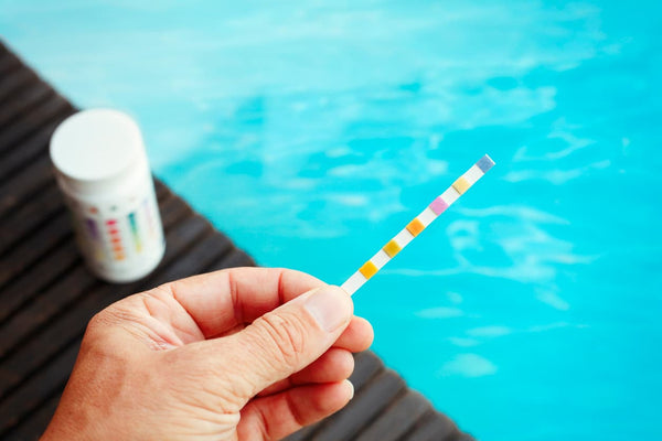 Person uses a testing kit to solve their swim spa’s pH imbalance