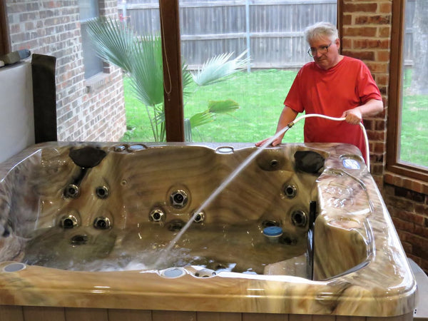 A senior man changes his spa water